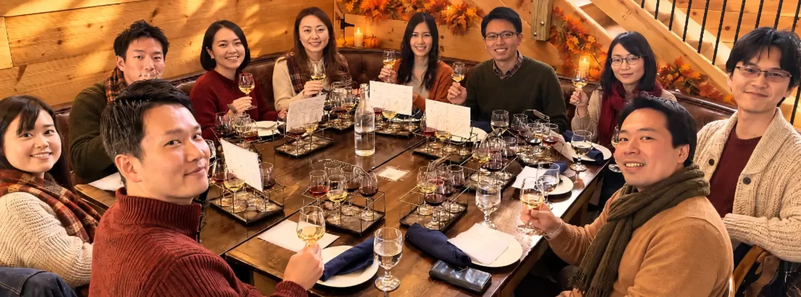 A group of friends sharing a wine tasting at a wooden table, glasses raised