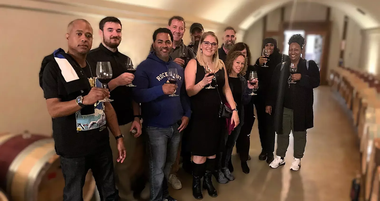 Corporate team enjoying a private wine tasting in a barrel room in Virginia wine country.