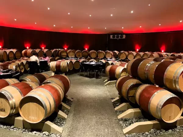 Dimly lit wine cave lined with oak barrels, offering guests a rare, behind-the-scenes look at Virginia winemaking craftsmanship.