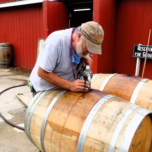 Doug Fabbioli, renowned Loudoun County winemaker, working on an oak wine barrel at Fabbioli Cellars, showcasing Virginia’s local craftsmanship and wine heritage.