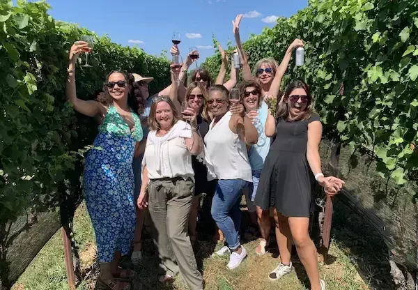 Guests raising glasses during a private Virginia vineyard tour, celebrating friendship, laughter, and handcrafted local wines.